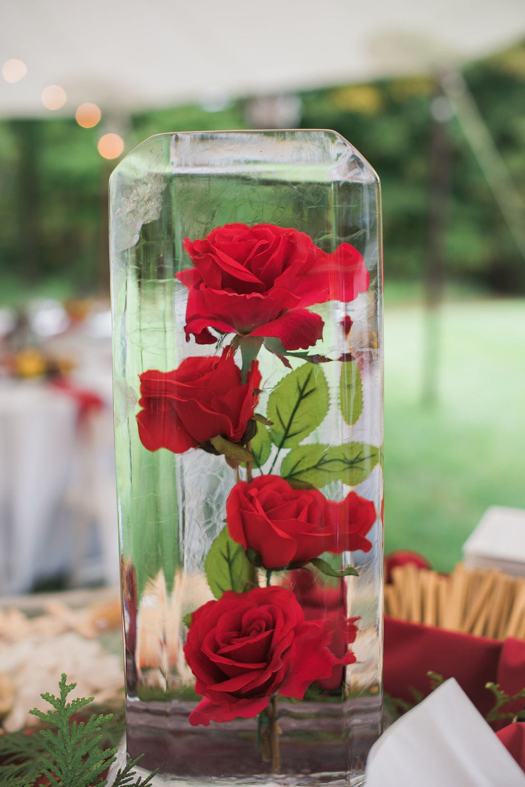 Three red roses preserved in clear ice