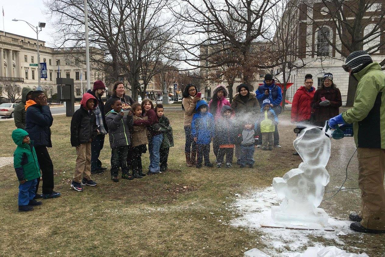 Crowd of people and students gathering outdoors near a winter ice display