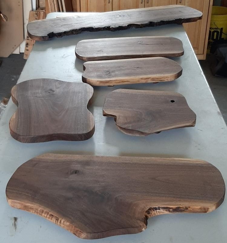 Handcrafted natural edge wooden serving boards resting on a display surface