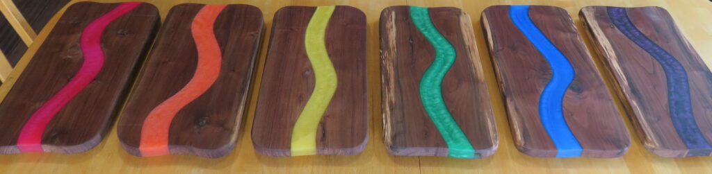 Artistic wooden blocks inlaid with smooth wavy green epoxy resin stripes