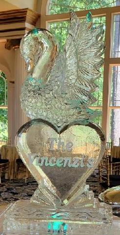 The custom engraved swan heart ice carving at an event venue