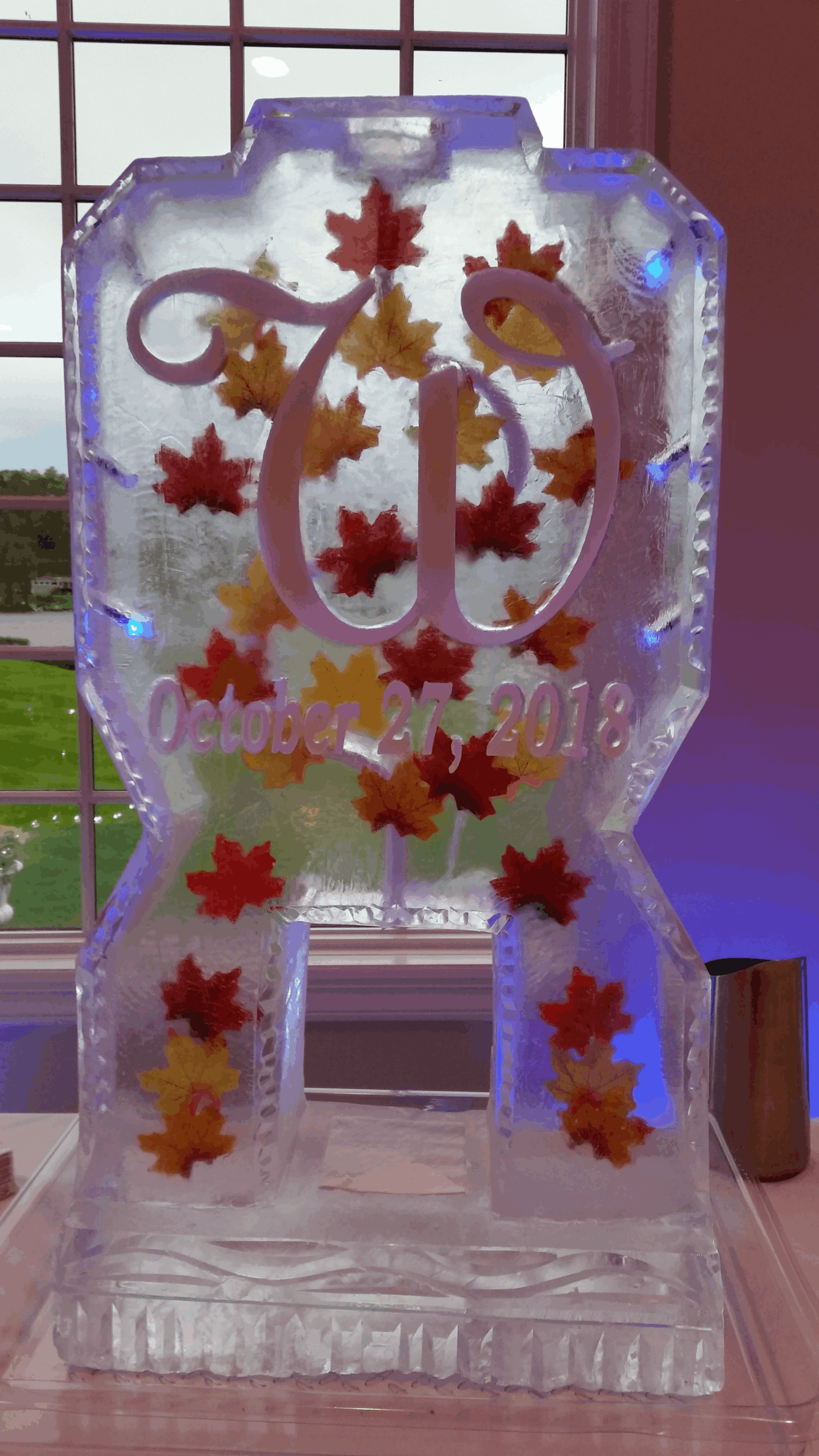 Autumn-themed monogram ice sculpture with decorative maple leaves