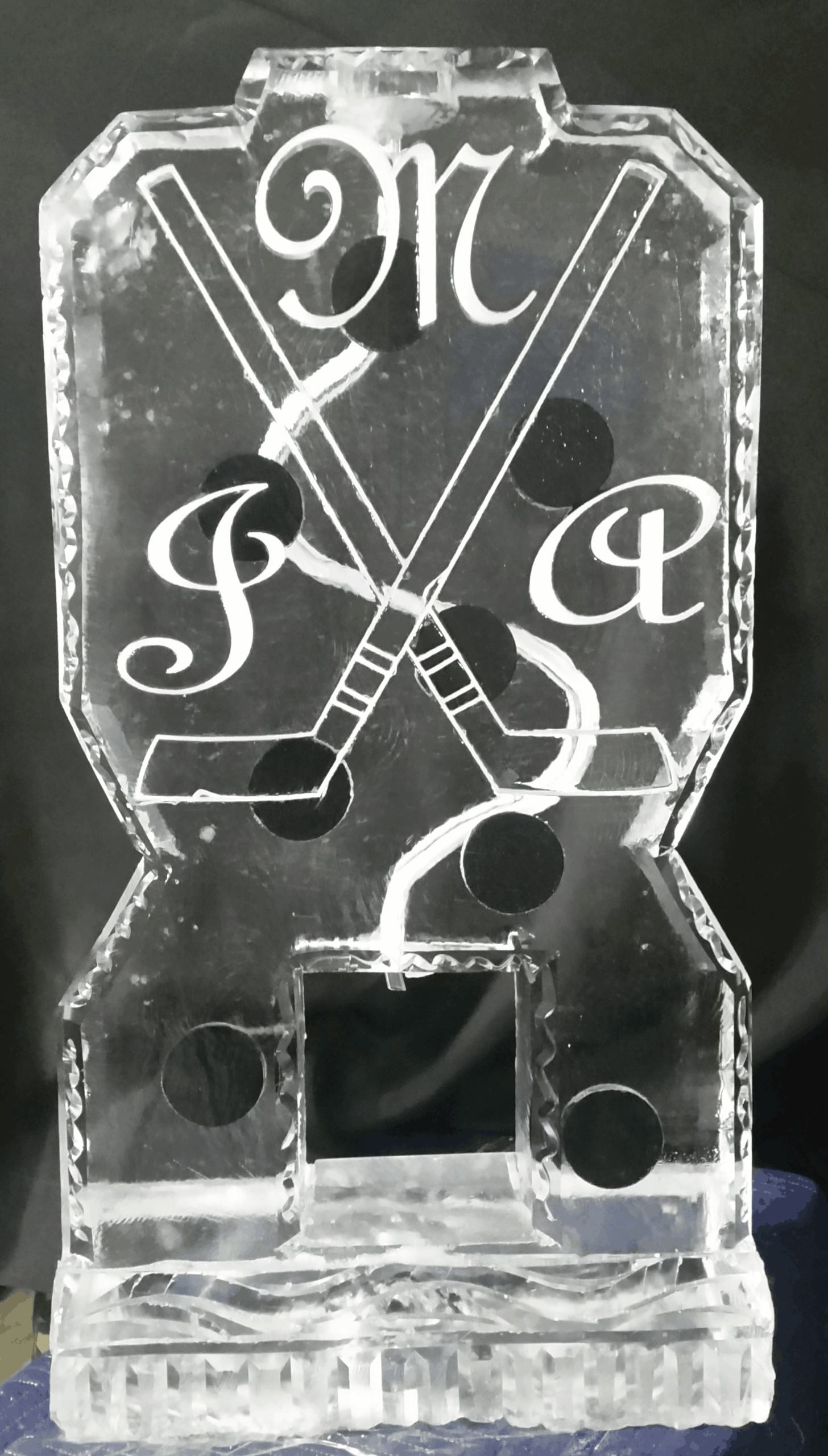 Monogram ice sculpture with crossed hockey sticks and initials