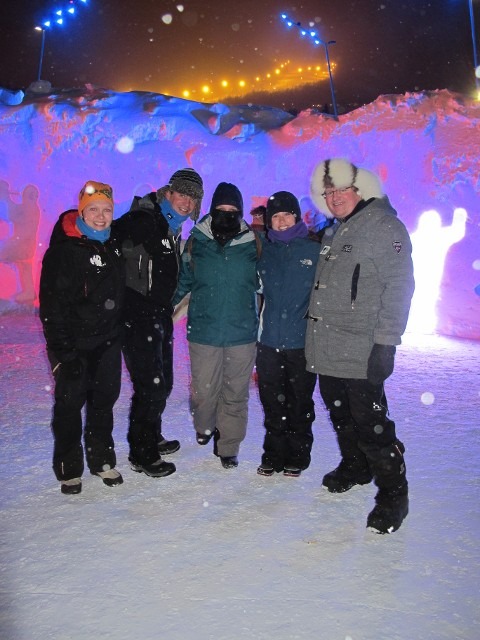 Winter event visitors posing for photos inside an artistic glowing ice sculpture hall