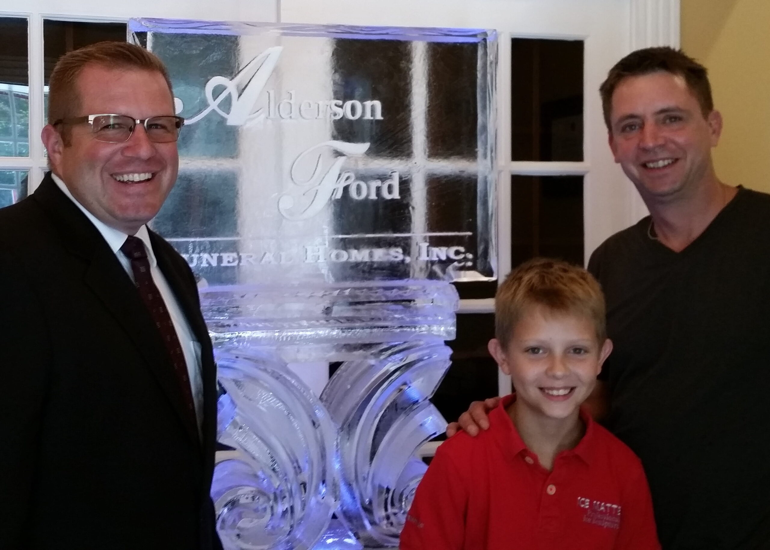 Event guests posing behind a custom ice sculpture at a corporate reception