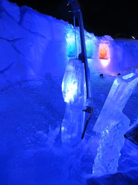 Intricate clear ice blocks glistening under bright architectural purple and blue lighting