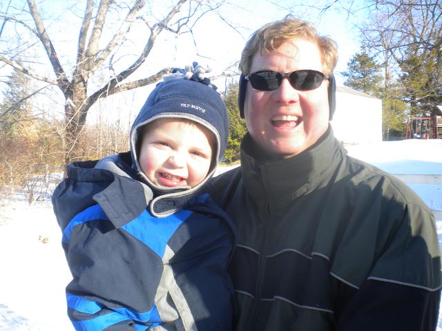 Happy adult and child bundled up in winter clothes smiling outdoors