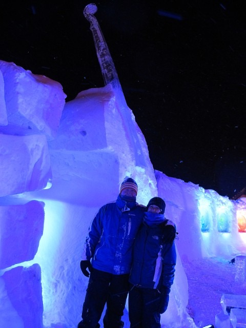 Event attendees walking through a massive structural blue lit ice cavern gallery