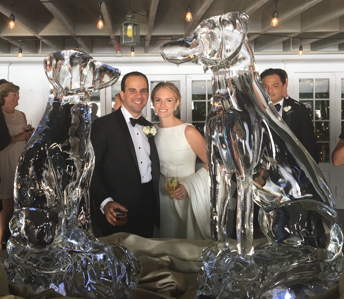 Wedding couple posing beside custom ice sculpture