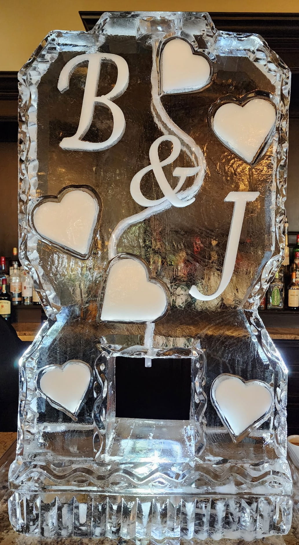 Custom wedding ice sculpture with intertwined initials and heart accents