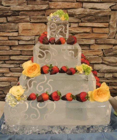 Decorative wedding cake displayed on an elegant ice sculpture cake stand