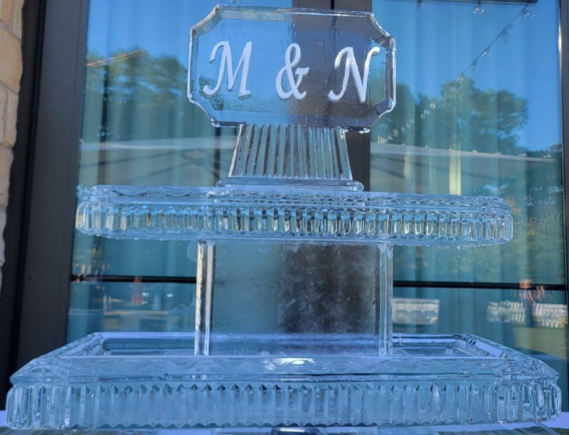 Personalized M & N monogram ice sculpture displayed on an ice pedestal