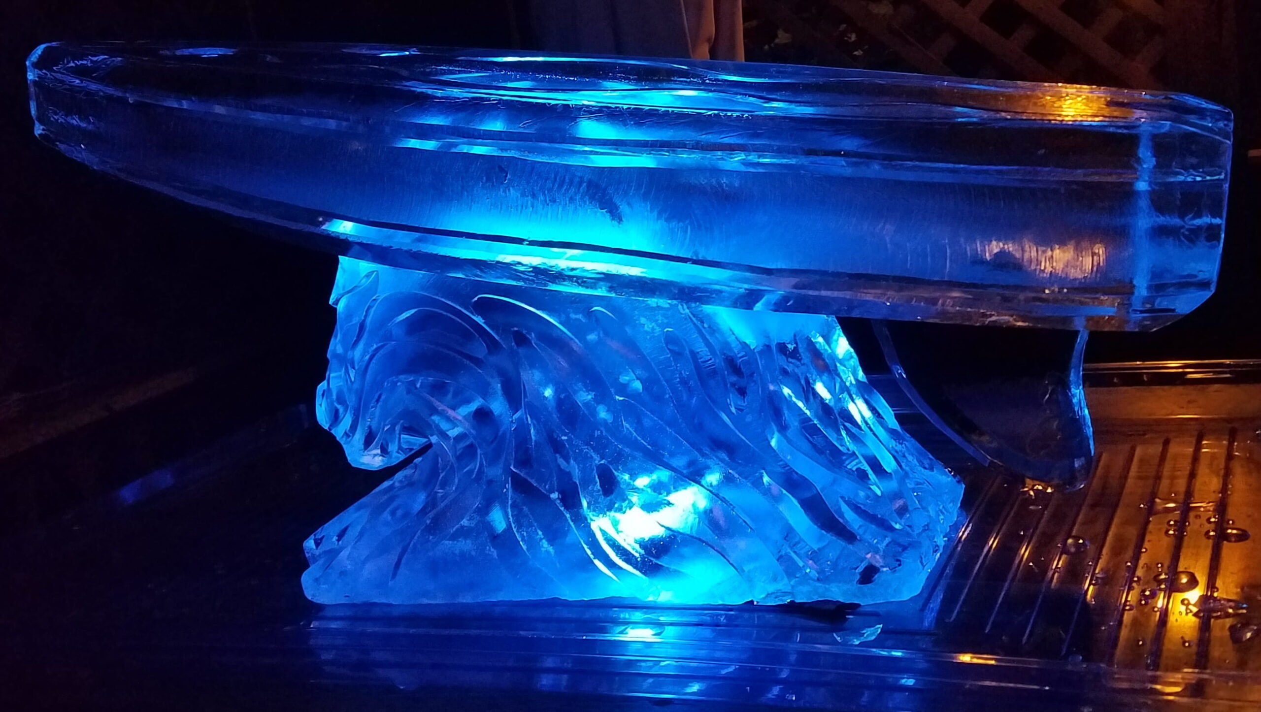 Blue illuminated wave ice sculpture