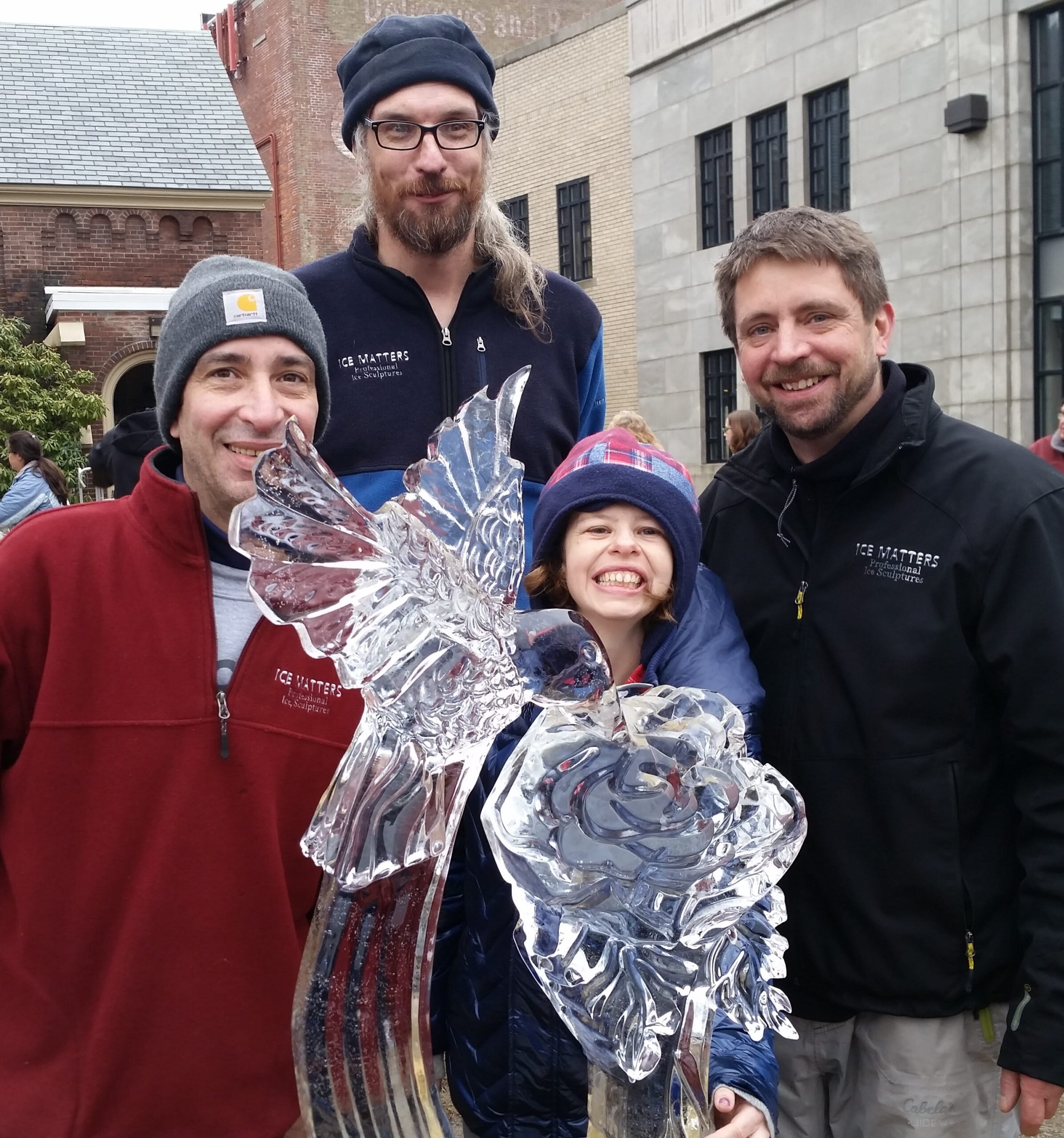 Smiling family posing together with a small decorative ice sculpture
