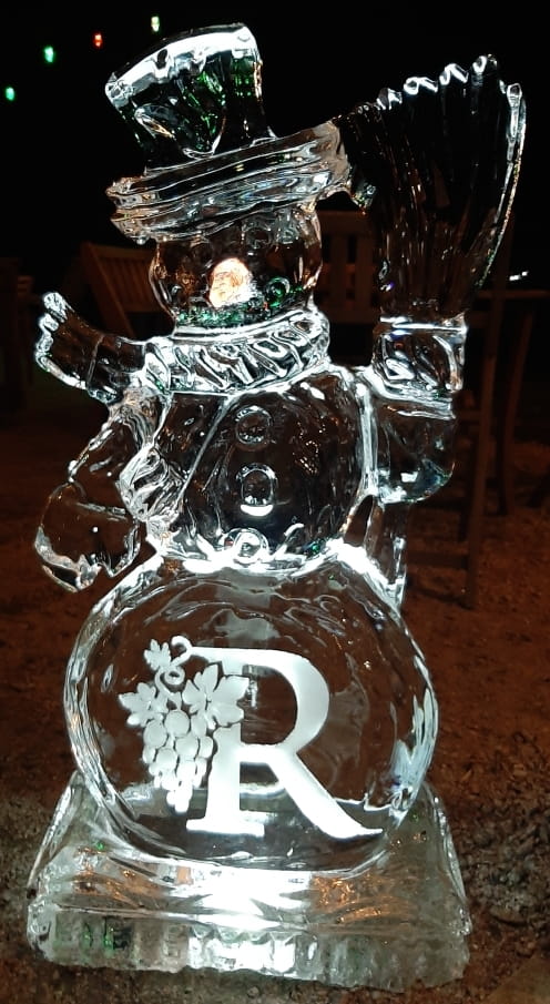 Festive Christmas snowman ice sculpture glowing under event lights