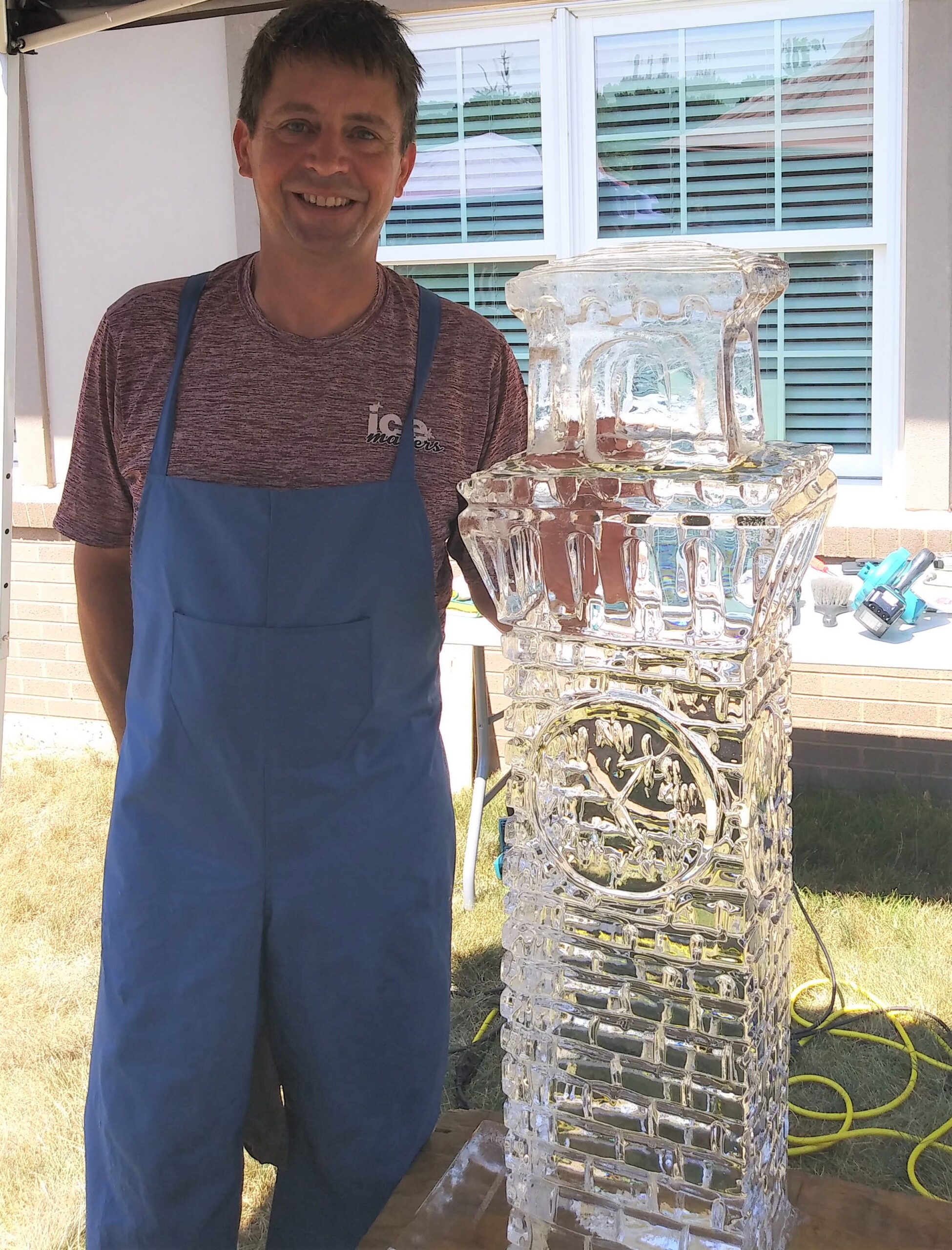 Man standing next to a custom vertical geometric block ice sculpture