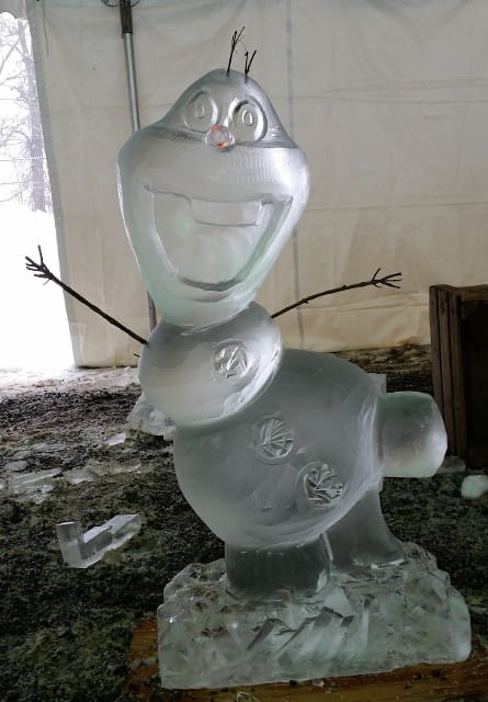 Whimsical ice carving of a bird or penguin figure on a table