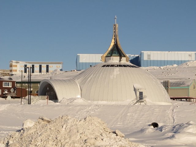 Modern structural geodesic dome pavilion tent situated in a wide open snow field