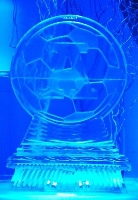 Blue illuminated globe ice sculpture