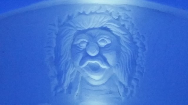 Detailed ice carving portrait of a bearded man or wizard face
