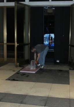 An event staff member setting up a custom low profile ice block layout indoors