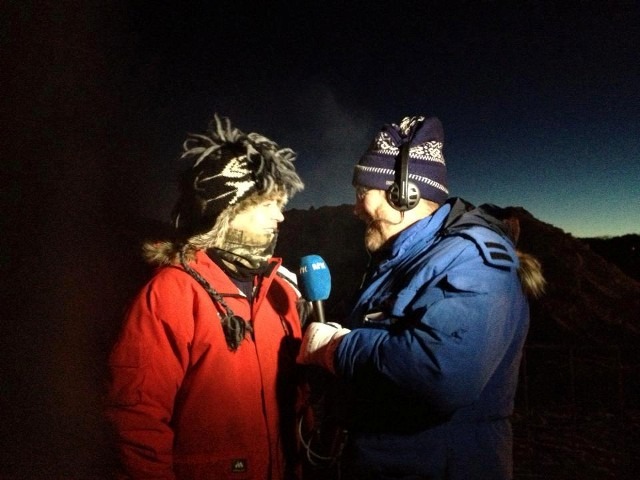 Two winter event coordinators talking into a microphone at an evening festival