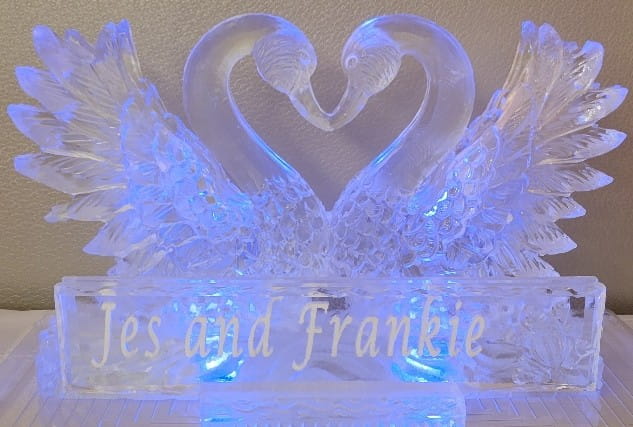 Elegant double swan wedding ice sculpture on a display stand
