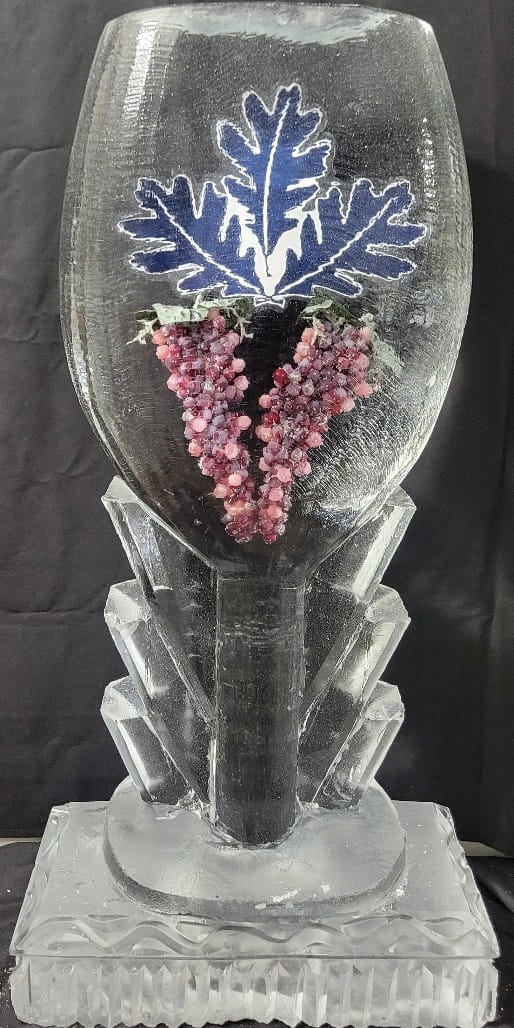 Close up of an ice luge display containing real frozen purple grapes