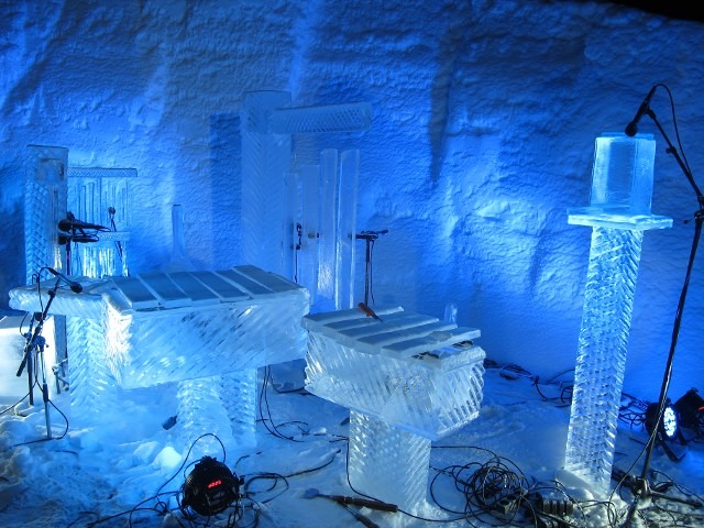 A series of large monolithic ice blocks standing vertical in an ice palace hall
