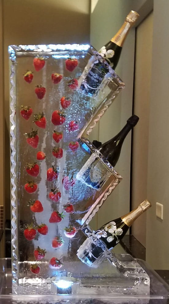 Champagne bottle ice luge with strawberries