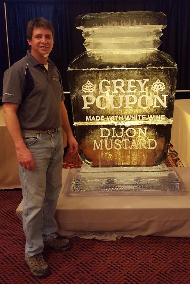 Grey Poupon Dijon Mustard branded bottle ice sculpture next to event staff