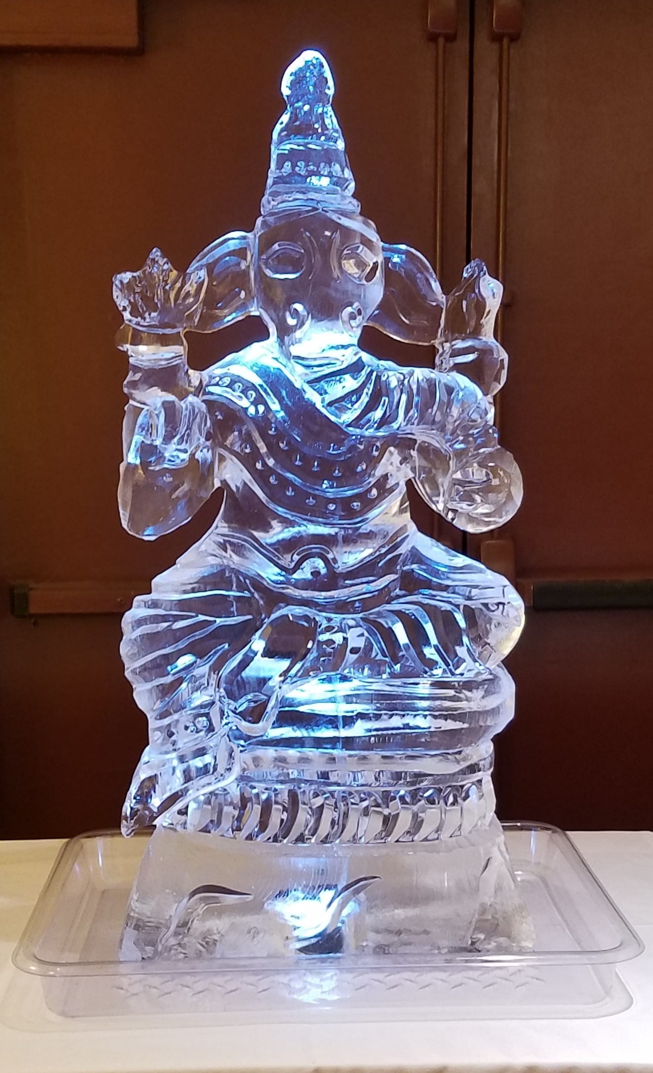 Laughing Buddha ice sculpture with blue illumination